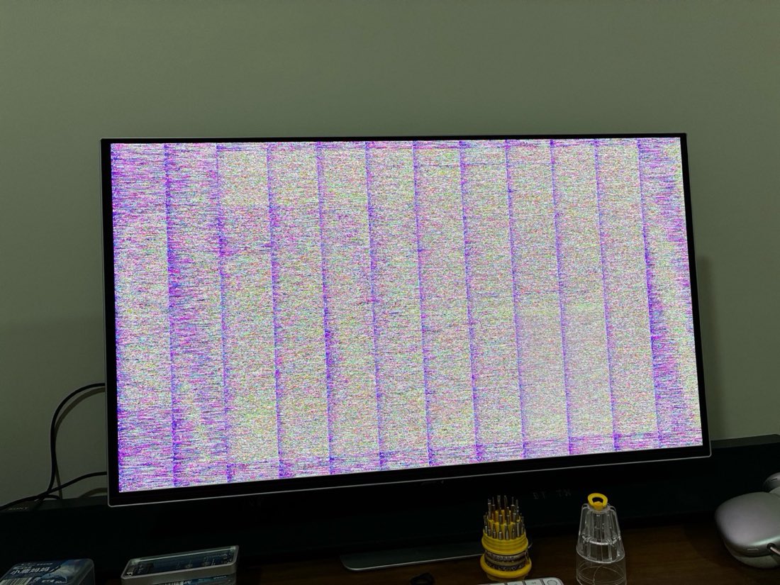 A Samsung G80SD monitor showing full-screen coloured static divided by purple vertical lines into 12 equal bands